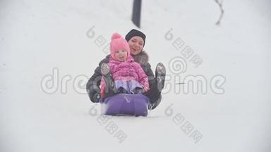 带着母亲在雪地里雪橇的笑孩子